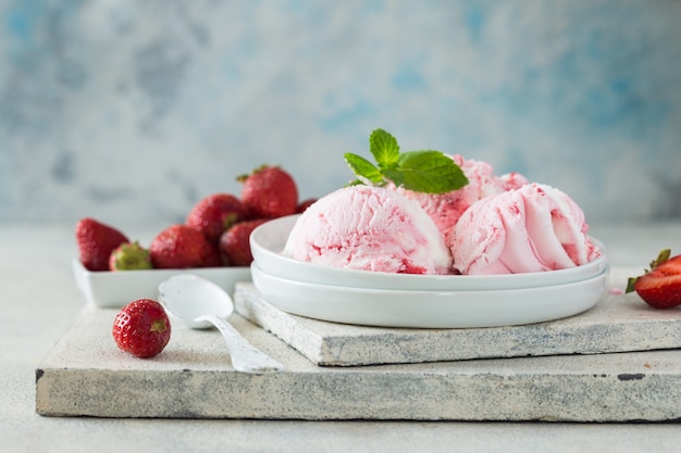 Zelfgemaakte aardbeien vanille-ijs scoops met verse aardbeien