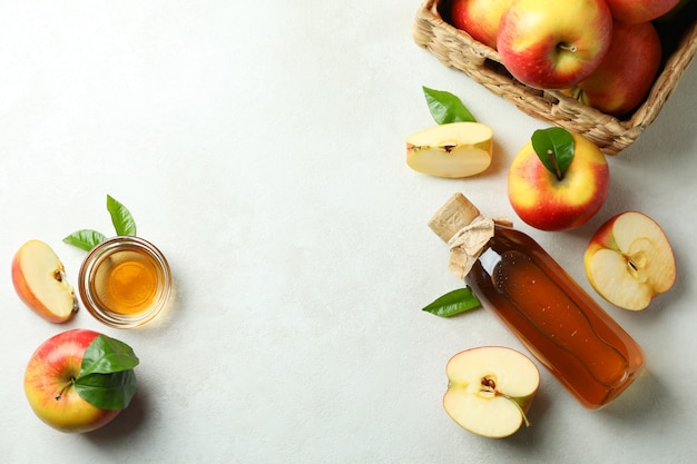 Zelfgemaakte appelazijn en ingrediënten op witte tafel