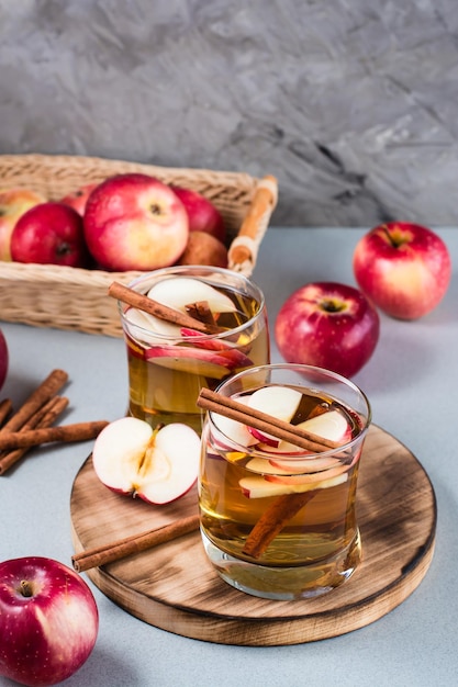 Zelfgemaakte appelcider met kaneel in glazen op een grijze achtergrond. Verwarmende winterdrankjes. Verticale weergave