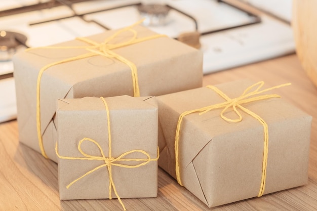 Zelfgemaakte bakkerijmaaltijden bezorgen Rustieke papieren handgemaakte geschenkdozen vastgebonden met geel koord