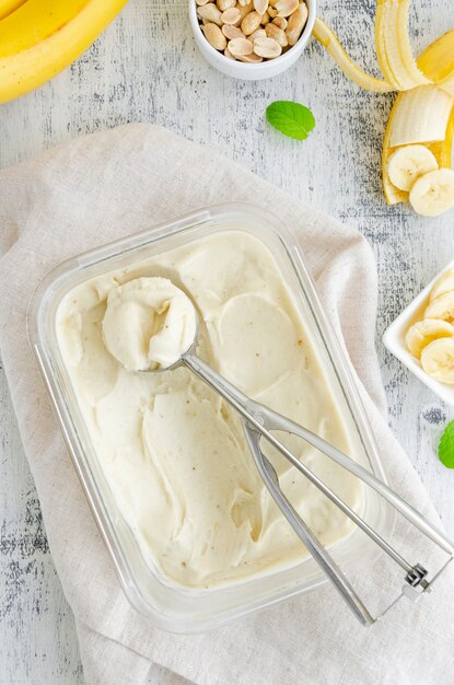 Zelfgemaakte bananen-ijs in een glazen container met een lepel voor ijs