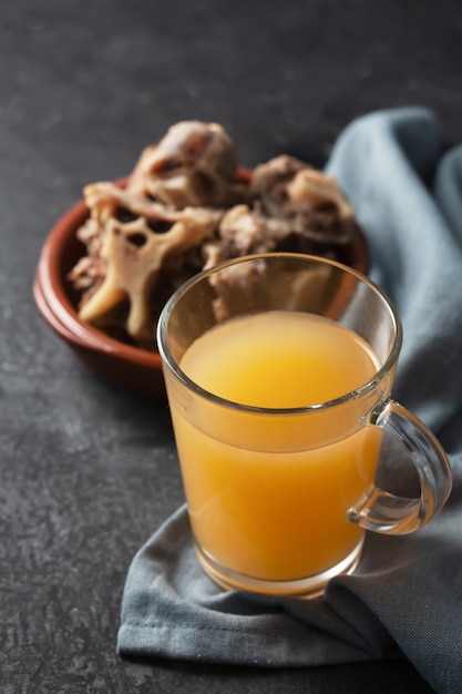 Zelfgemaakte Beef Bone Bouillon in glazen voorraadpot op een zwarte ruimte. Donkere stijl