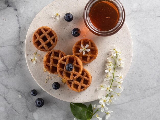 Zelfgemaakte Belgische wafels met bosbessen en honing op marmeren tafel Vertical