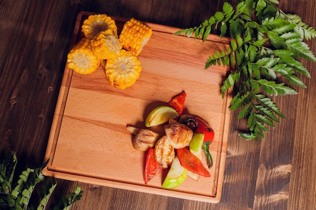 Zelfgemaakte biologische gegrilde zomergroenten op rustieke tafel maïs peper ui aubergine courgette veget