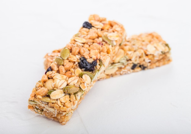 Zelfgemaakte biologische granola granen bars met noten en gedroogd fruit op wit.