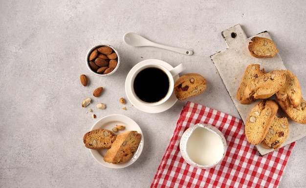 Zelfgemaakte biscotti met amandel en met espresoo-koffie op een rood servet met crème top vie kopieerruimte