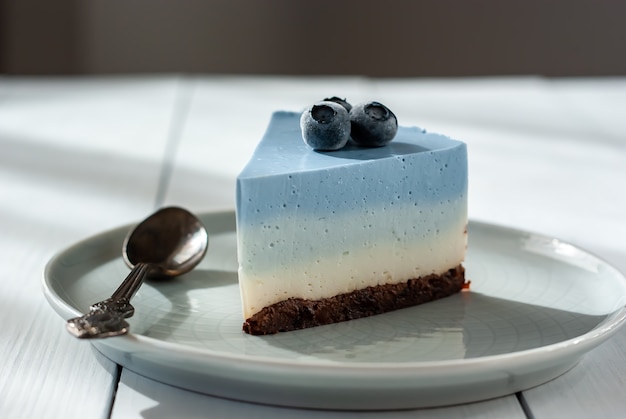 Zelfgemaakte blauwe vlinder pea cheesecake met verse bessen op een lichte tafel