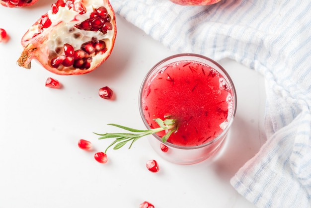 Zelfgemaakte boozy alcoholische granaatappelcocktail met rozemarijn en wodka, wit marmer, hoogste mening