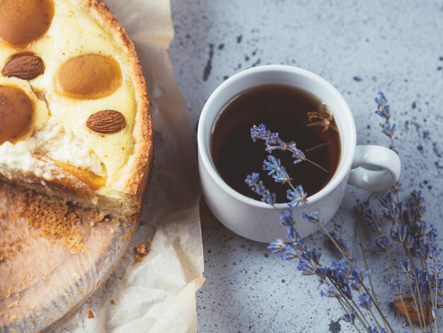 Zelfgemaakte cake met amandelen en abrikozen. Een kopje kruidenthee met lavendel.