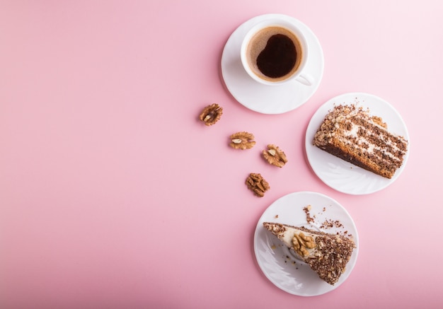 Zelfgemaakte cake met melkroom en walnoten met kopje koffie op roze