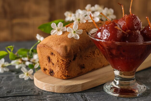 Zelfgemaakte cake versierd met kersenbloemen en appeljam op tafel. Zelfgemaakte zoetigheden volgens oude recepten.