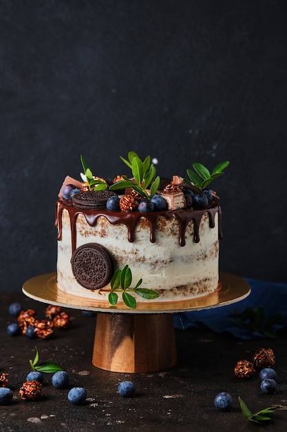 Zelfgemaakte cake voor de vakantie met roomkaasroom, versierd met chocoladekoekjes en bessen.