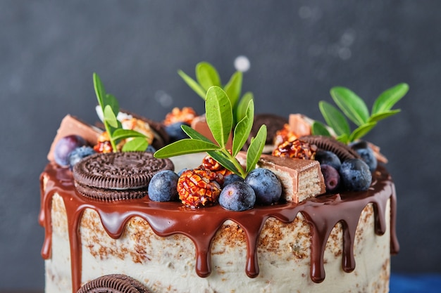 Zelfgemaakte cake voor de vakantie met roomkaasroom, versierd met chocoladekoekjes en bessen.