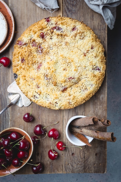 Zelfgemaakte cherry crumble taart met verse bessen op rustiek