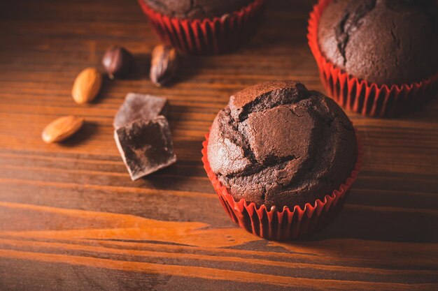 Zelfgemaakte chocolade muffins of cupcakes op een houten plank