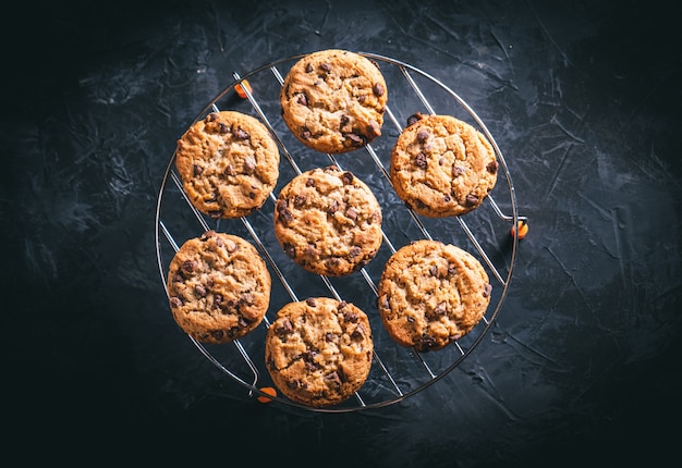 Zelfgemaakte chocoladekoekjes op een metalen rek op een donkere tafel