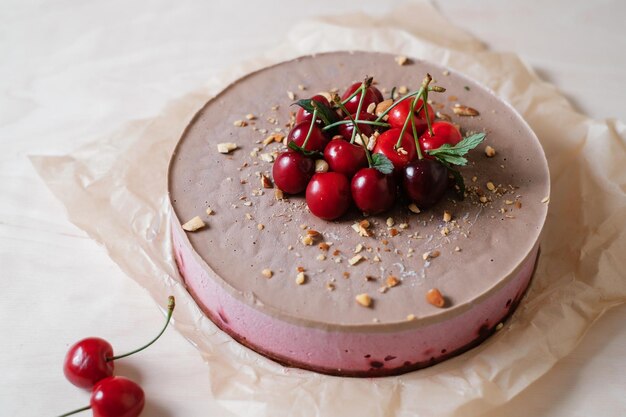 Zelfgemaakte chocoladetaart met kers op perkamentpapier Voedsel levering Zelfgemaakt bakken Bovenaanzicht Heerlijke taart met chocolade en kers op de houten tafel close-up