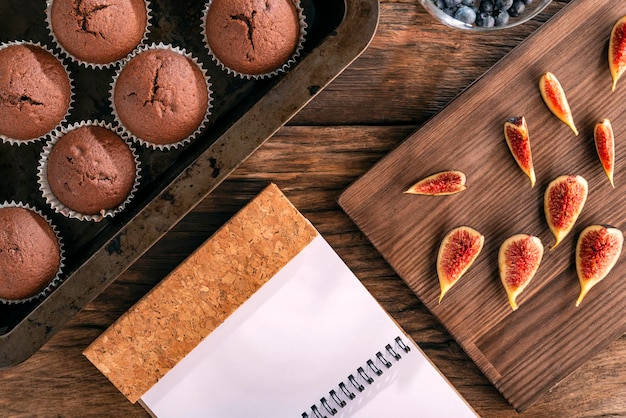 Zelfgemaakte chocoladetaarten in Bakvormen Verse vijgen en notitieboekje op houten ondergrond Culinair plat leggen Bovenaanzicht