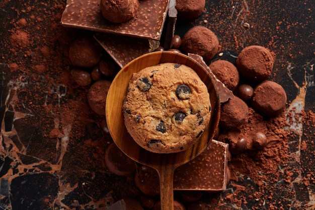 Zelfgemaakte chocolate chip cookies op een houten lepel met cacaopoeder en snoep