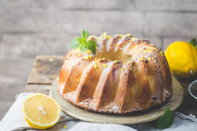 Zelfgemaakte citroen bundt cake met poedersuiker op een zwarte achtergrond