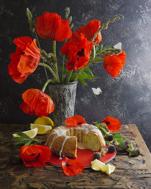 Zelfgemaakte citroen gebonden cake en rode bloemen. Vliegende vlinders