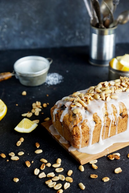 Zelfgemaakte citroencake met rozijnen, noten en vanille glazuur op donkere stenen ondergrond