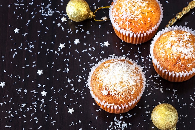 Zelfgemaakte citroenmuffins versieren de donkere achtergrond van kokospoeder. Nieuwjaar en Kerstmisconcept. Selectieve aandacht.