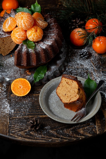 Zelfgemaakte Citrus Tangerine cake versierd met poedersuiker en mandarijn op houten tafel achtergrond