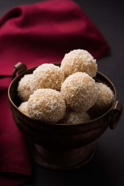 Zelfgemaakte Coconut Sweet Laddoo OF Nariyal Laddu gemaakt met gecondenseerde melk en suiker, populair festivalvoedsel. Geserveerd op een humeurige achtergrond, selectieve focus