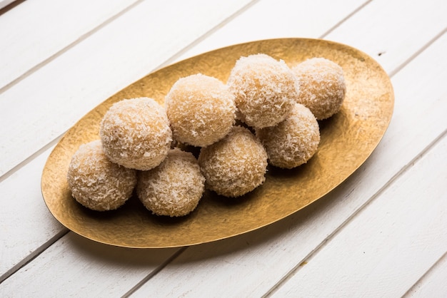 Zelfgemaakte Coconut Sweet Laddoo OF Nariyal Laddu gemaakt met gecondenseerde melk en suiker, populair festivalvoedsel. Geserveerd op een humeurige achtergrond, selectieve focus