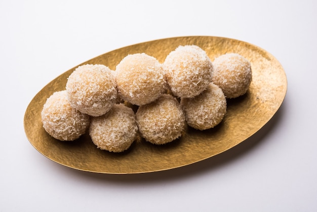 Zelfgemaakte Coconut Sweet Laddoo OF Nariyal Laddu gemaakt met gecondenseerde melk en suiker, populair festivalvoedsel. Geserveerd op een humeurige achtergrond, selectieve focus