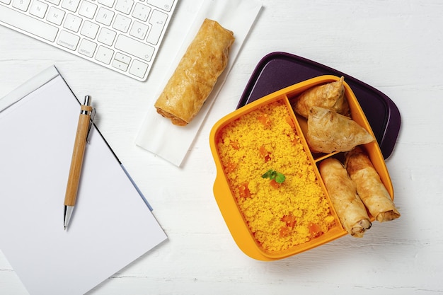 Zelfgemaakte Couscous in een lunchbox met groenten en typisch Arabisch eten Take away Food in work concept