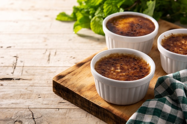 Zelfgemaakte crème brulee in kom op houten tafel