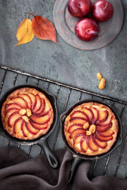 Foto zelfgemaakte crumble pruimtaartjes gebakken in kleine ijzeren koekenpannen op koelrek