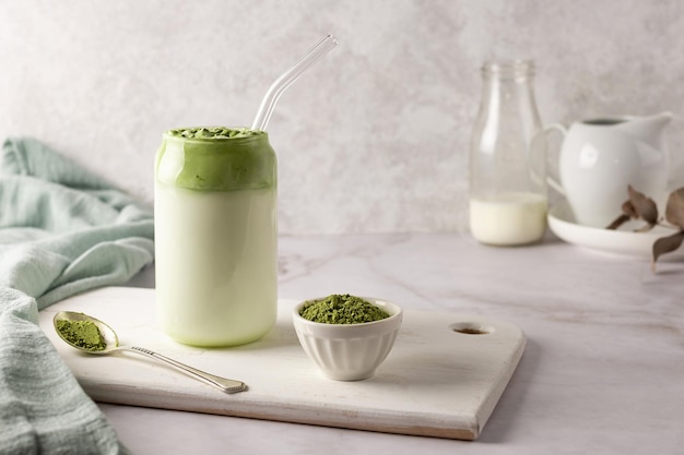 Zelfgemaakte dalgona matcha latte en lepel groene theepoeder.