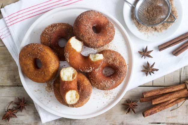 Zelfgemaakte donuts met suiker en kaneel op een houten achtergrond. Rustieke stijl.