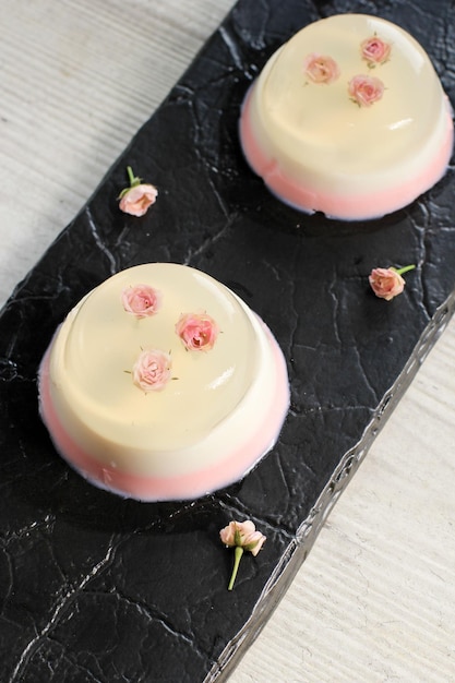 Zelfgemaakte doorzichtige mini-roos roze gelaagde pudding in een kopje, een variant van eetbare bloempuddingdecoratie