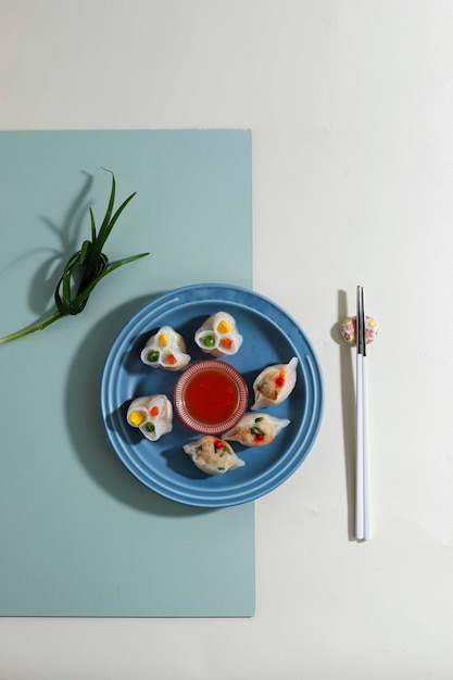 Zelfgemaakte dumplings dim sum met gevulde garnalen en groente in een blauwe plaat op tafel. ruimte kopiëren, bovenaanzicht