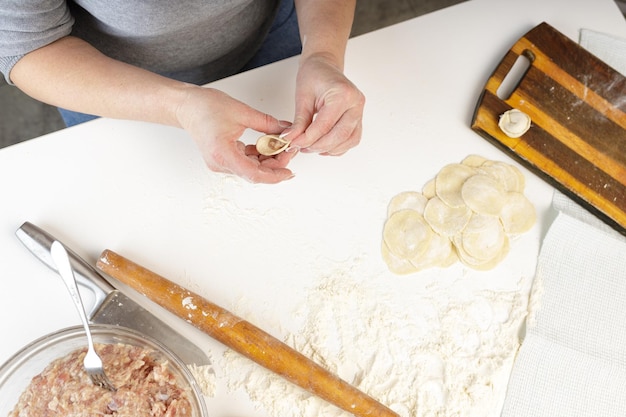 Zelfgemaakte dumplings in de keuken zonder versieringen. dumplings maken met varkensgehakt, rundvlees en kip