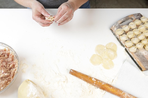 Zelfgemaakte dumplings in de keuken zonder versieringen. dumplings maken met varkensgehakt, rundvlees en kip