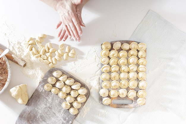 Zelfgemaakte dumplings in de keuken zonder versieringen. dumplings maken met varkensgehakt, rundvlees en kip