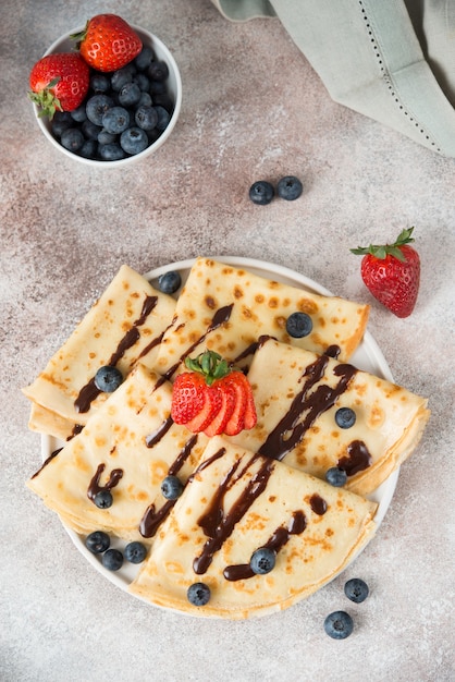 Zelfgemaakte dunne pannenkoeken met bessen en chocolade