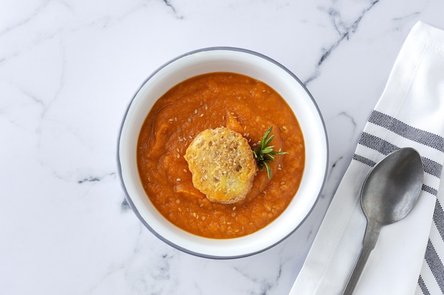 Zelfgemaakte en gezonde pompoencrème met brood van bovenaf op marmeren tafel. Plat leggen