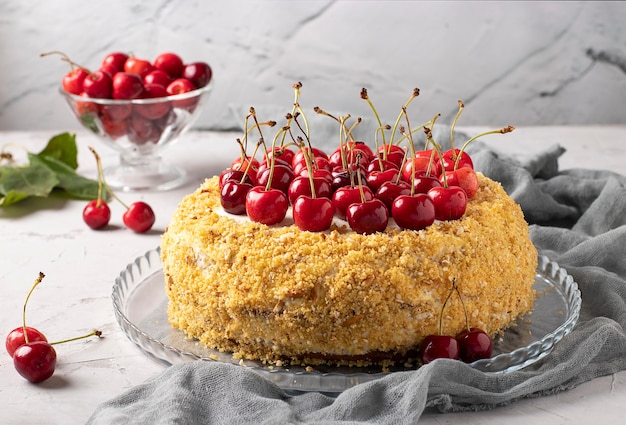 Zelfgemaakte feestelijke cake met zoete kersen op een grijze achtergrond. Detailopname. Top van de taart is versierd met verse zoete kersen