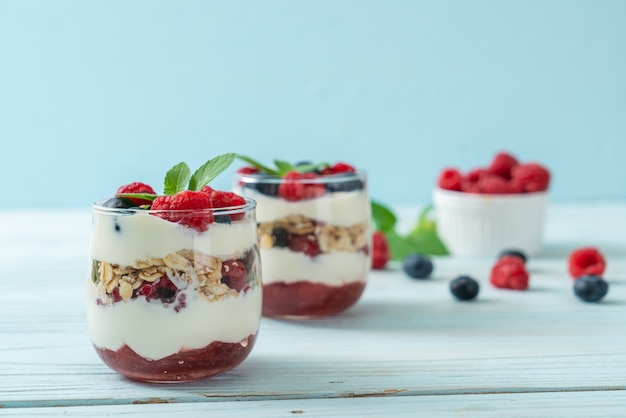 zelfgemaakte frambozen en bosbessen met yoghurt en granola - gezonde voedingsstijl