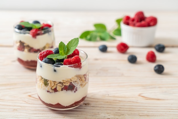zelfgemaakte frambozen en bosbessen met yoghurt en granola - gezonde voedingsstijl