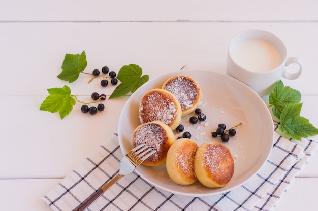 Zelfgemaakte gebakken cheesecakes met melk en bessen, close-up