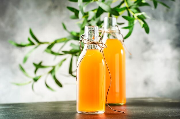 Zelfgemaakte gefermenteerde rauwe kombuchathee klaar om te drinken grijze keukentafel achtergrond met kopie ruimte