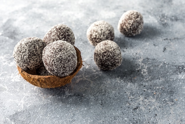 Zelfgemaakte gezonde eiwit energie ballen in een kokos kom met gedroogde abrikozen, rozijnen, walnoten, amandelen en kokos. Gezond zoet eten