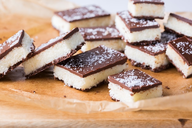 Foto zelfgemaakte gezonde energie biologische rauwe veganistische kokosrepen met chocolade op een keukentafel